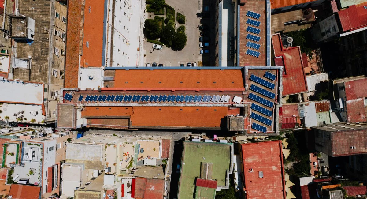 Aerial view of red-roofed urban buildings adorned with solar panels, Napoli, Italy.