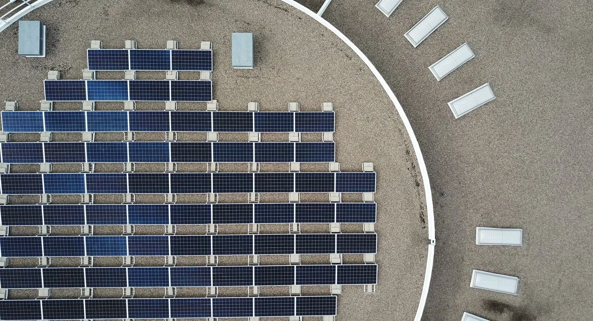 Aerial shot of solar panels on an urban rooftop, showcasing renewable energy technology.